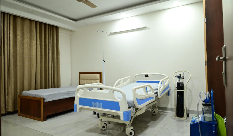 A nurse providing wound care and dressing changes to a senior patient in a clean, private room, showcasing Post operative care in elderly care facility in India.