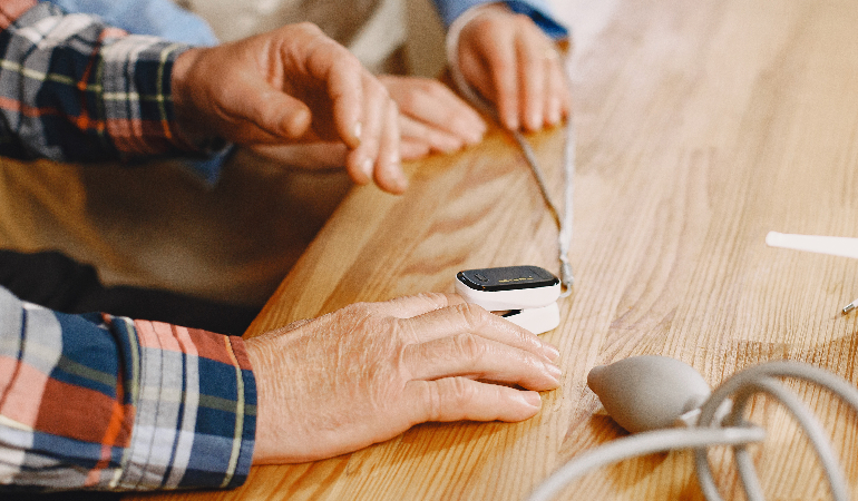 A group of seniors engaged in a craft project or art therapy session in a brightly lit Senior day care facility in India.