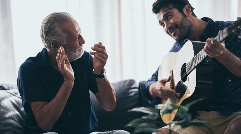 A senior resident engaged in music therapy, showcasing cognitive stimulation within a Luxury elder living with Alzheimer's Care specialist in India facility.