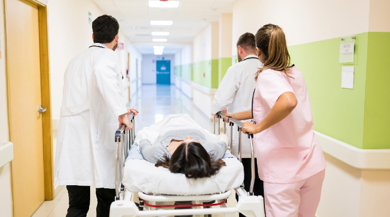 A nurse rushing to respond to an emergency alarm at a 24x7 nurse station, illustrating the faster emergency response protocol.