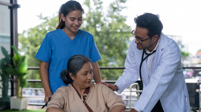 A skilled nurse checking a patient's vitals at a 24x7 nurse station, highlighting continuous supervision in a Senior care facility with round the clock healthcare in India