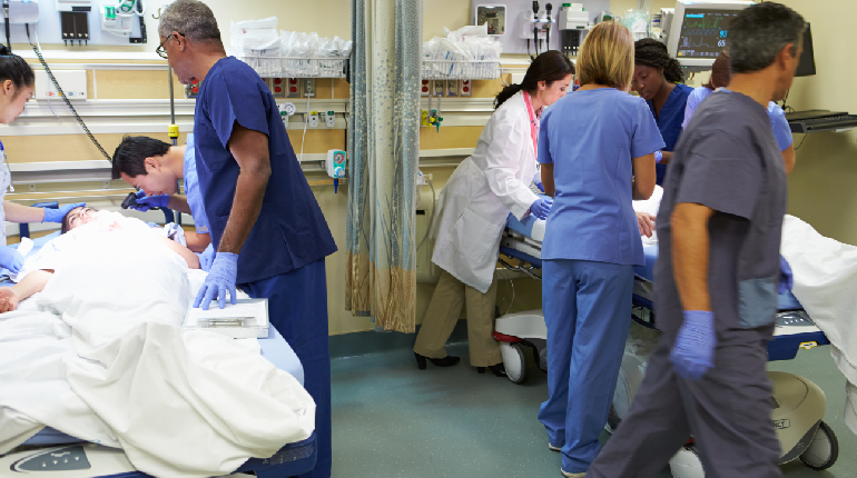 A nurse rushing to respond to an emergency alarm at a 24x7 nurse station, illustrating the faster emergency response protocol.
