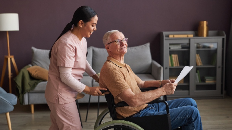 A senior resident smiling while painting an abstract canvas, highlighting "failure-free" activities in an Elderly care home with Dementia care in India.
