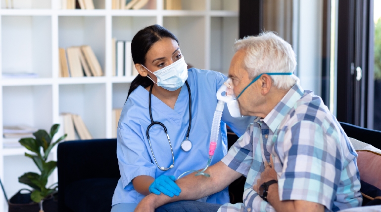 A professional nurse organizing medications for a resident at a specialized home with geriatric care for seniors in India