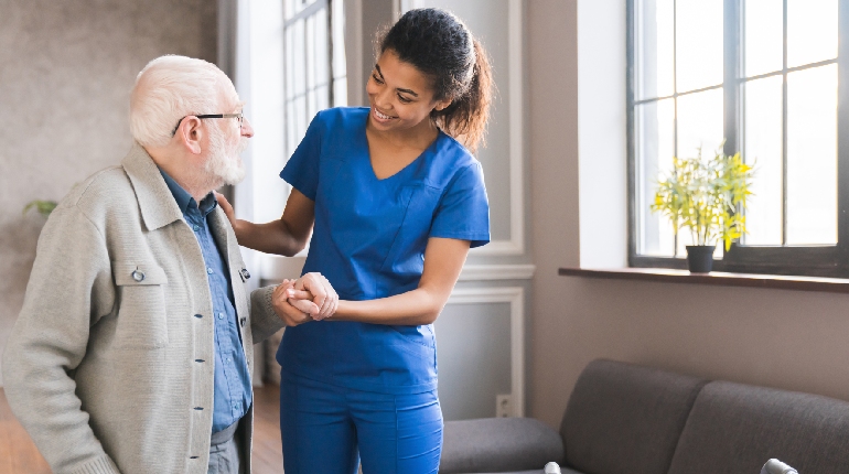 A senior resident participating in a supervised heart-healthy walk at a residential facility for elders with 24x7 healthcare support