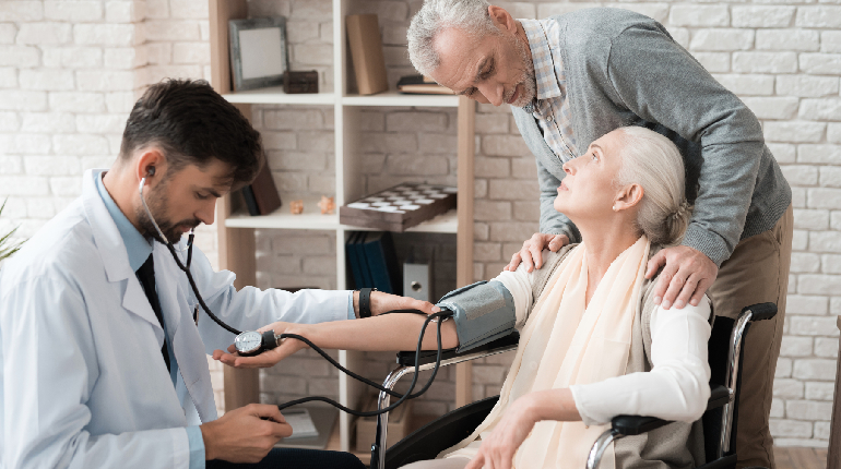 A medical professional performing regular health checks on an elderly resident