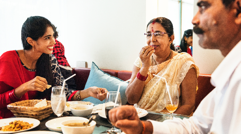 An elderly resident enjoying a morning meal with the support of professional staff.