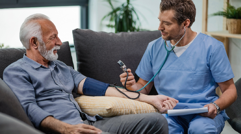 A nurse conducting regular health checks for a resident with hypertension
