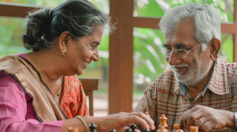 A senior resident participating in a cognitive memory matching game with a specialized therapist at a senior living in India with 24x7 health support