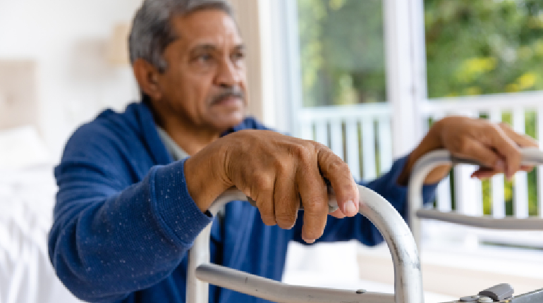 An elderly resident with low vision navigating a high-contrast corridor safely at Artha.